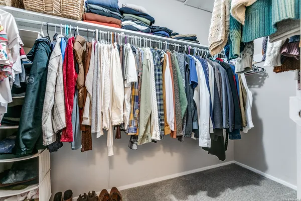 a view of walk in closet with clothes and shoes