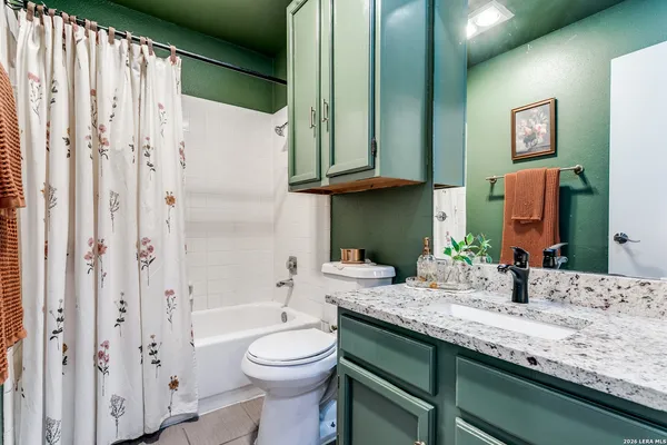 a bathroom with a granite countertop sink toilet and shower