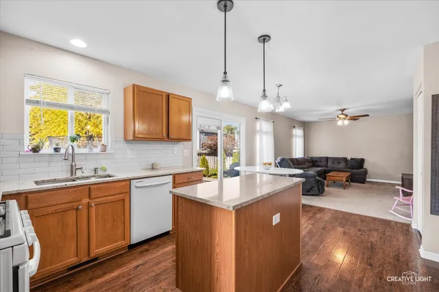 a kitchen with sink a center island and living room view