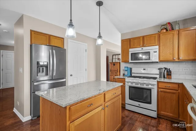 a kitchen with stainless steel appliances granite countertop a stove a refrigerator and a sink
