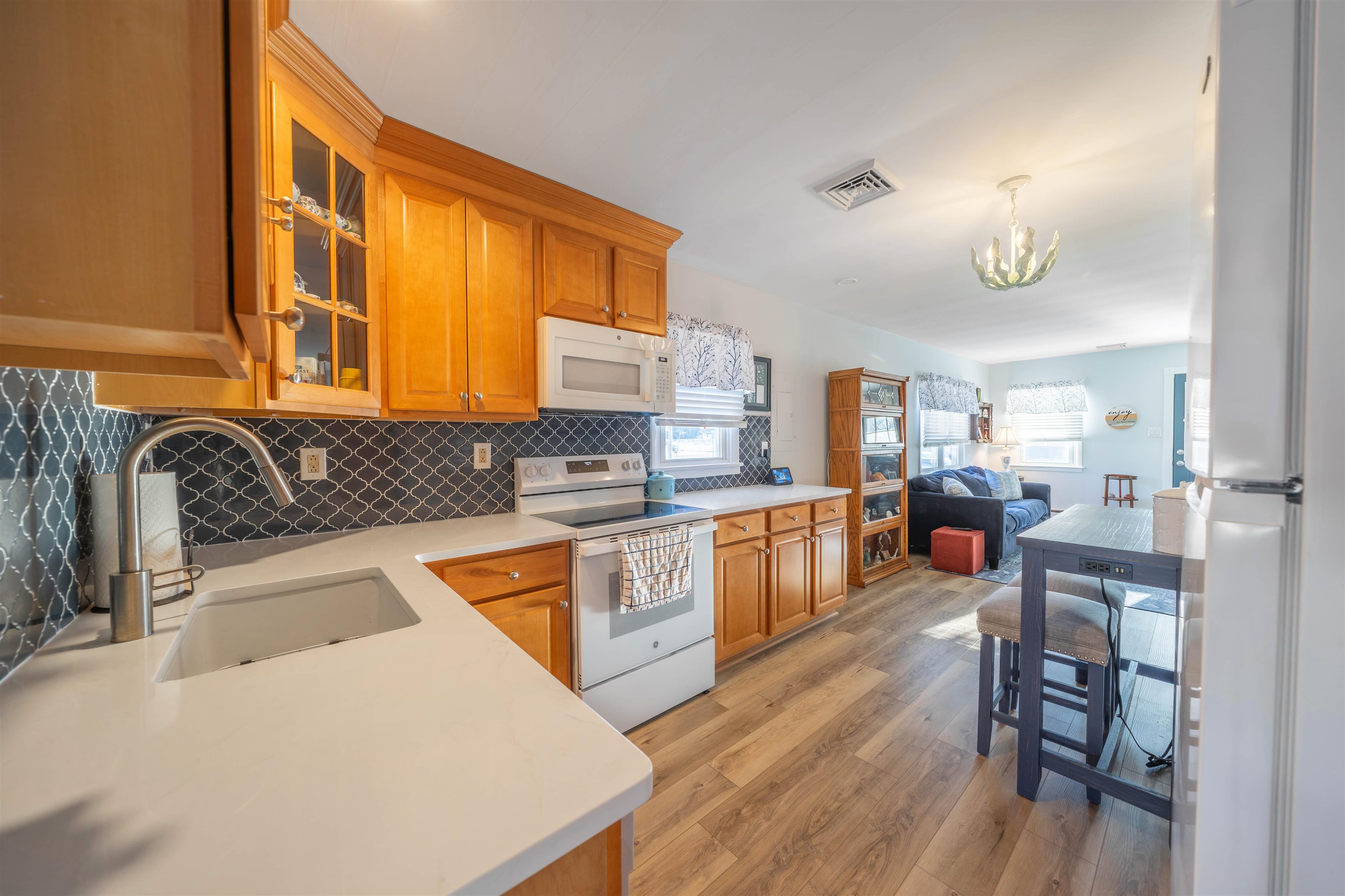 50 Vacation Villas, NJ 08251 - Photo 18 of 21 a kitchen with stainless steel appliances granite countertop wooden cabinets a sink a stove a dining table and chairs