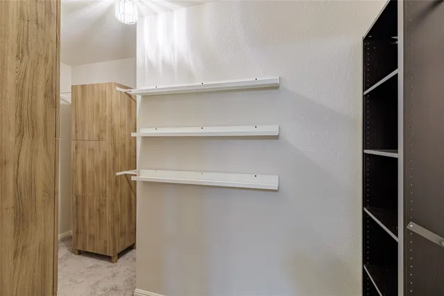 a view of walk in closet with empty racks