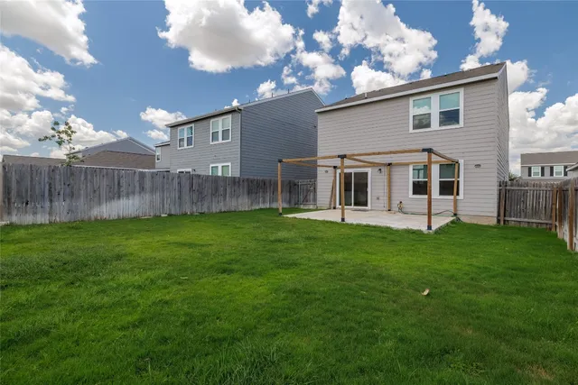 a view of a house with backyard and a tree