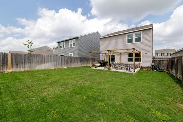 a view of a house with a backyard and a patio