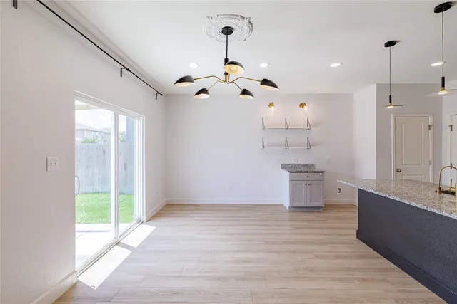 a view of a kitchen with wooden floor and a ceiling fan