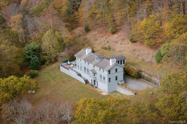 a front view of a house with a garden and mountain view