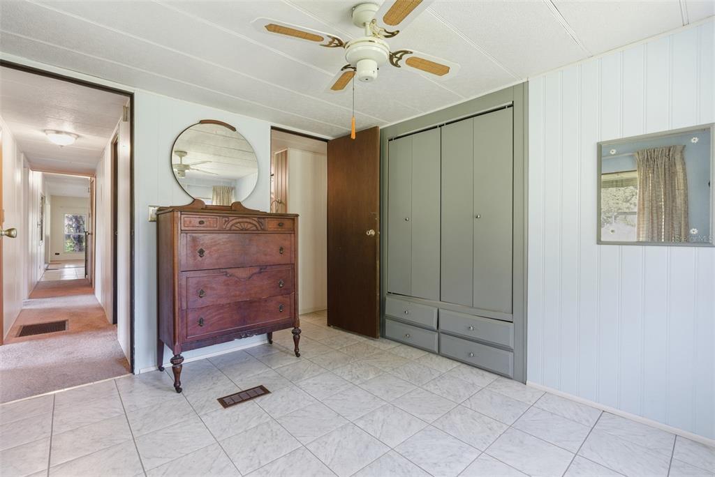 6147 Ridgewood Drive Zephyrhills, FL 33542 - Photo 12 of 21 an empty room with mirror and a chandelier fan