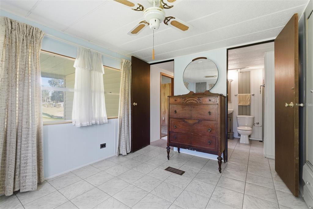 6147 Ridgewood Drive Zephyrhills, FL 33542 - Photo 14 of 21 a bedroom with a bed and a chandelier