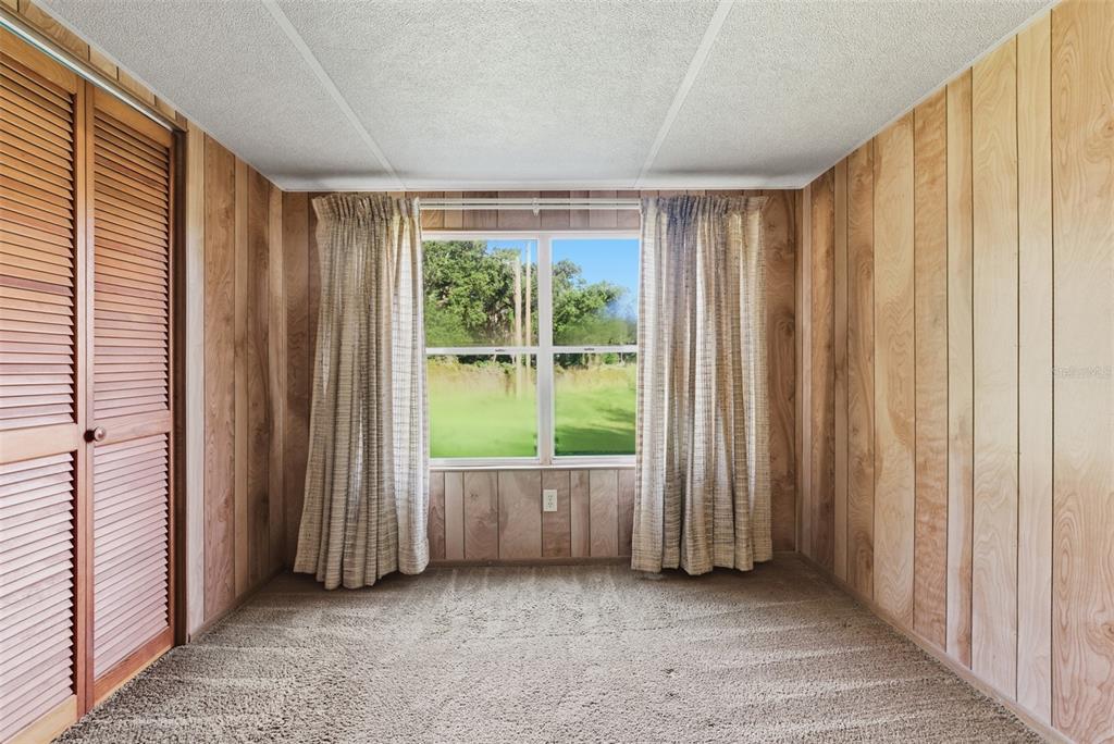 6147 Ridgewood Drive Zephyrhills, FL 33542 - Photo 16 of 21 a view of an empty room with wooden door and furniture