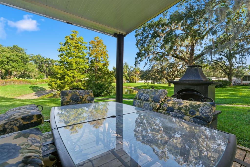 6147 Ridgewood Drive Zephyrhills, FL 33542 - Photo 4 of 21 a backyard of a house with table and chairs