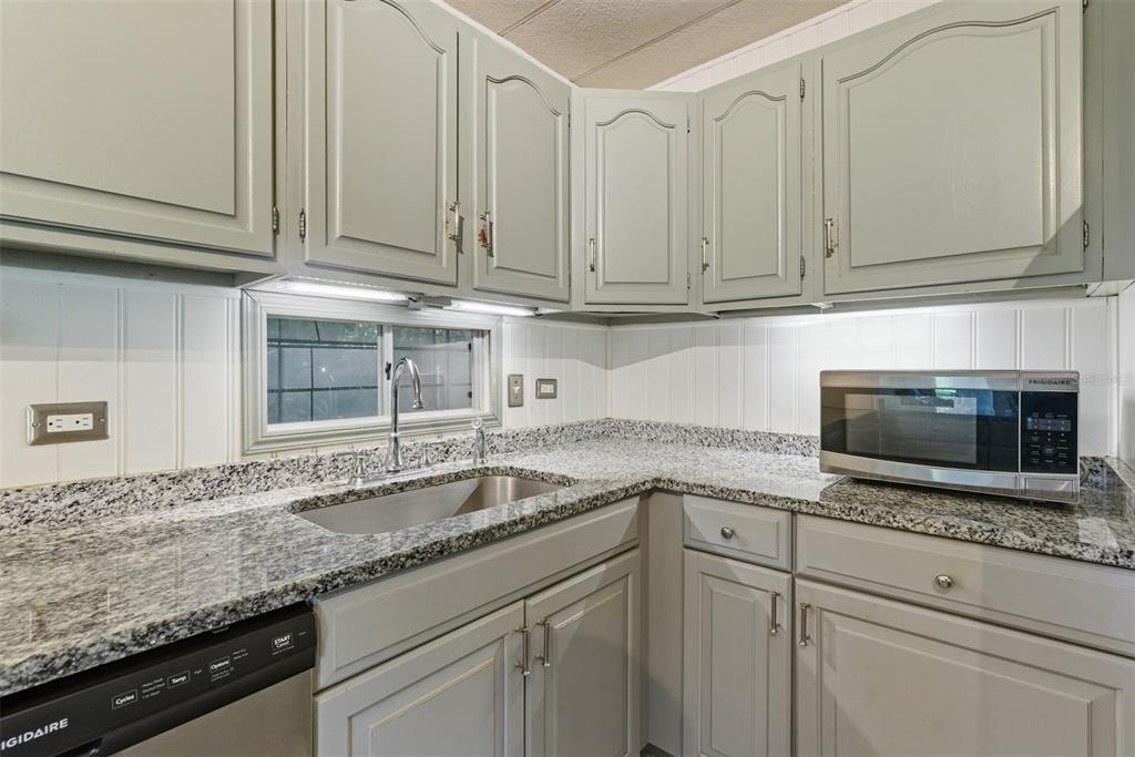 6147 Ridgewood Drive Zephyrhills, FL 33542 - Photo 6 of 21 a kitchen with granite countertop white cabinets and a sink