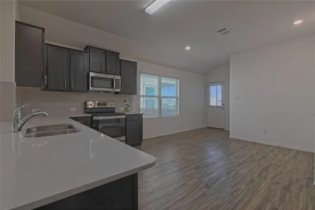 a kitchen with a sink a stove a microwave and cabinets