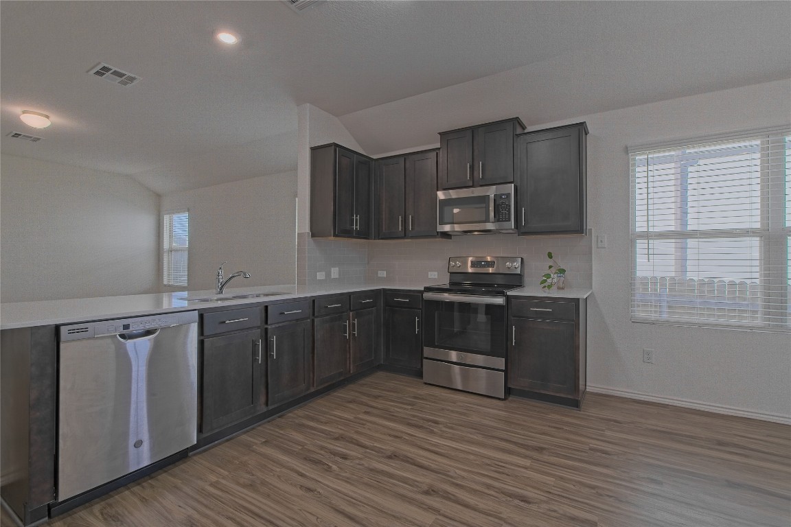 505 Greatest Gift Way Jarrell, TX 76537 - Photo 10 of 30 a kitchen with stainless steel appliances granite countertop a stove a sink and a microwave
