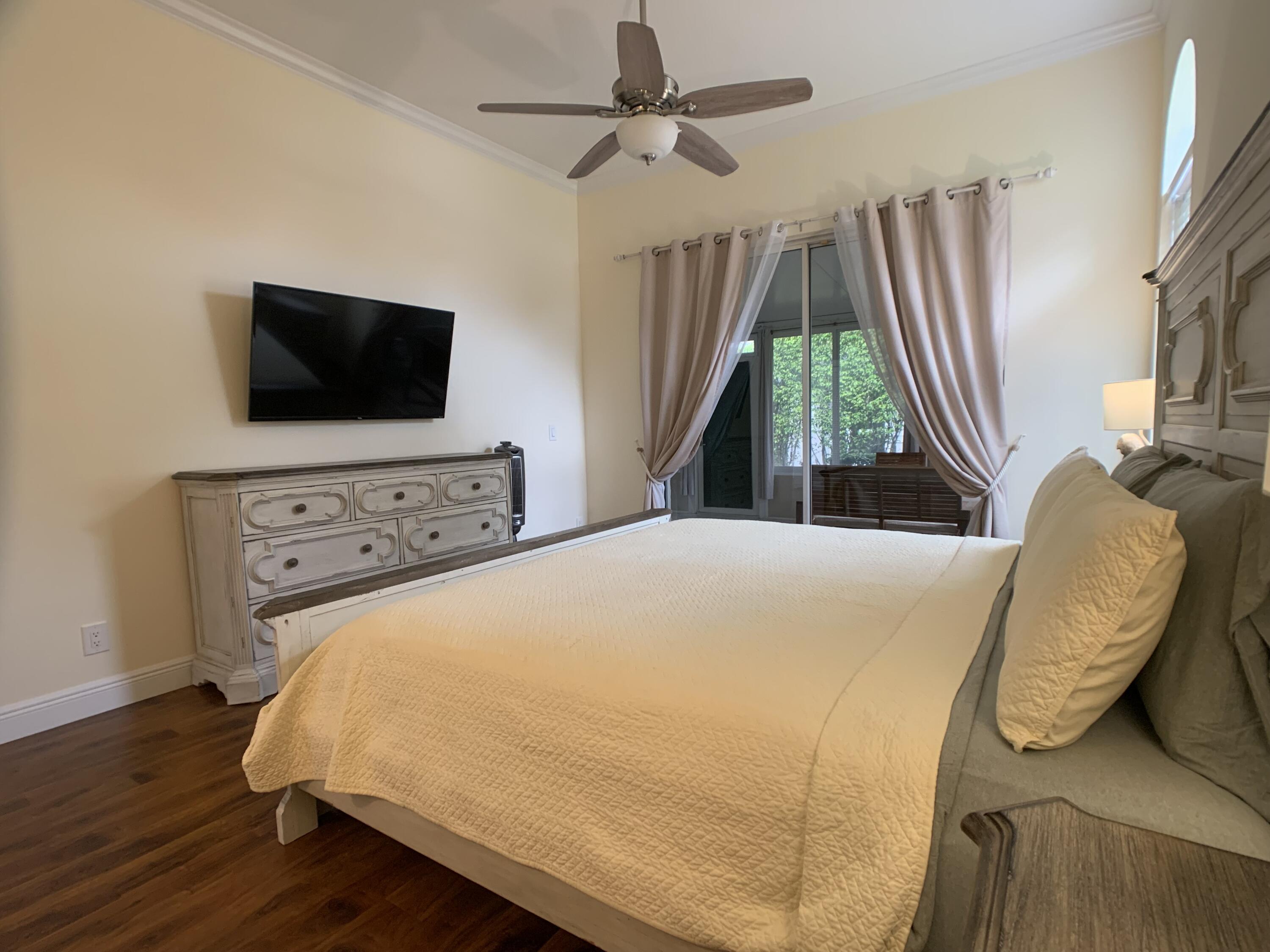 10465 Mateo Court Boca Raton, FL 33498 - Photo 12 of 36 a bedroom with a bed and a flat screen tv
