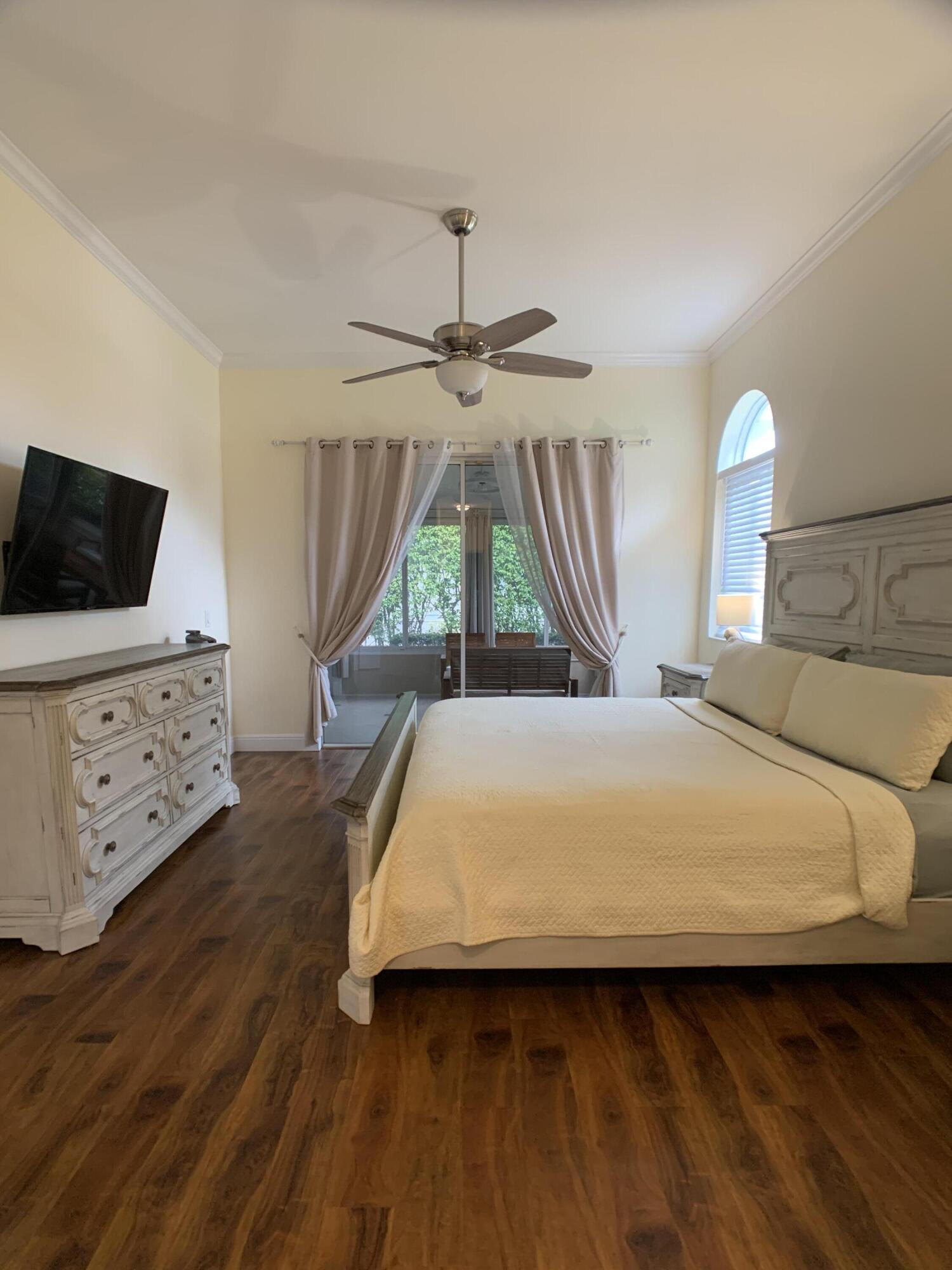 10465 Mateo Court Boca Raton, FL 33498 - Photo 13 of 36 a bedroom with a bed and a flat screen tv