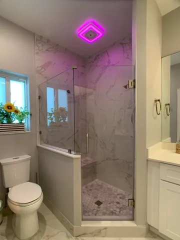 a bathroom with a shower sink mirror and toilet