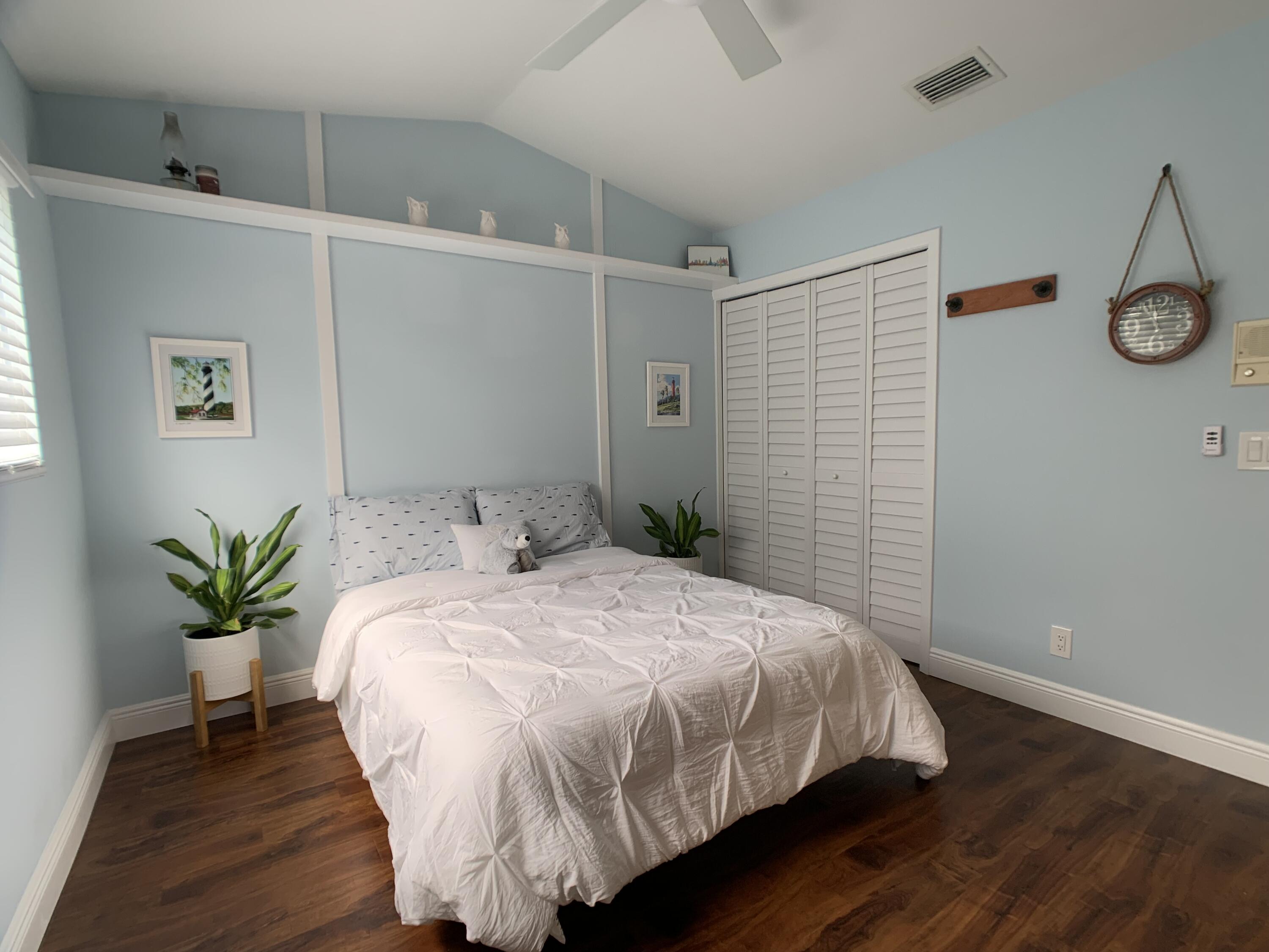 10465 Mateo Court Boca Raton, FL 33498 - Photo 23 of 36 a bedroom with a bed and a table in it