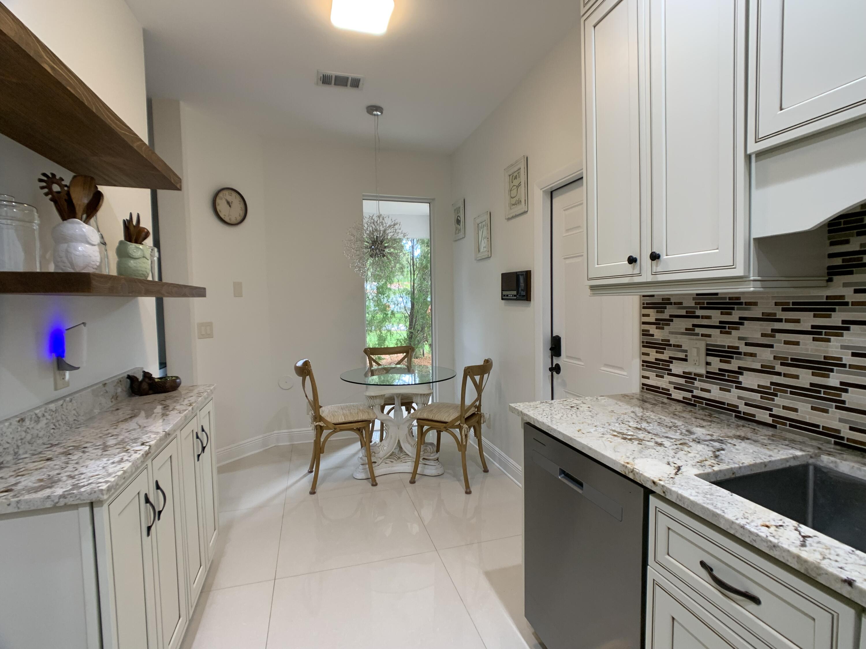 10465 Mateo Court Boca Raton, FL 33498 - Photo 3 of 36 a kitchen with granite countertop stainless steel appliances a sink a counter top space and cabinets