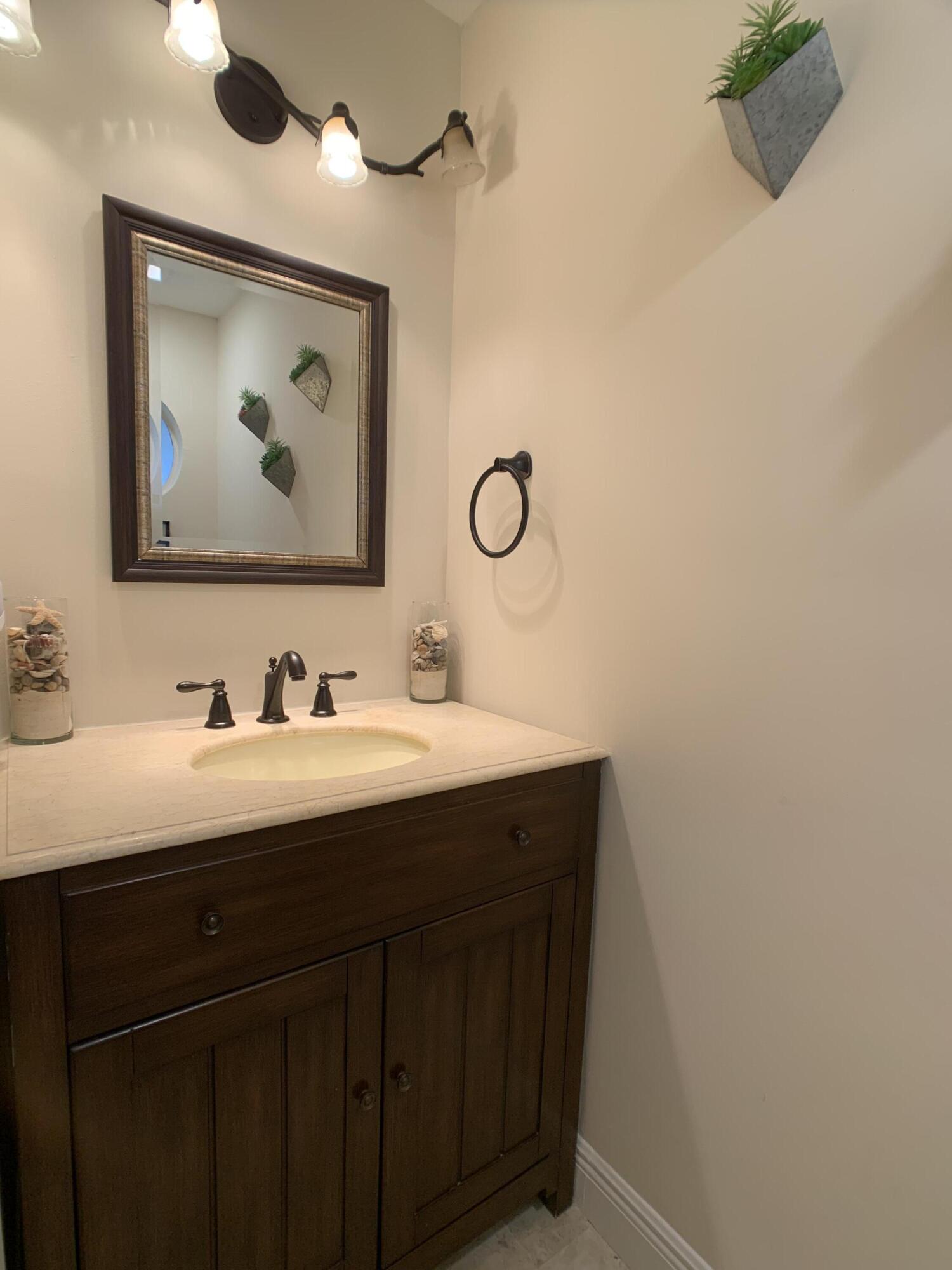 10465 Mateo Court Boca Raton, FL 33498 - Photo 33 of 36 a bathroom with a granite countertop sink mirror and vanity