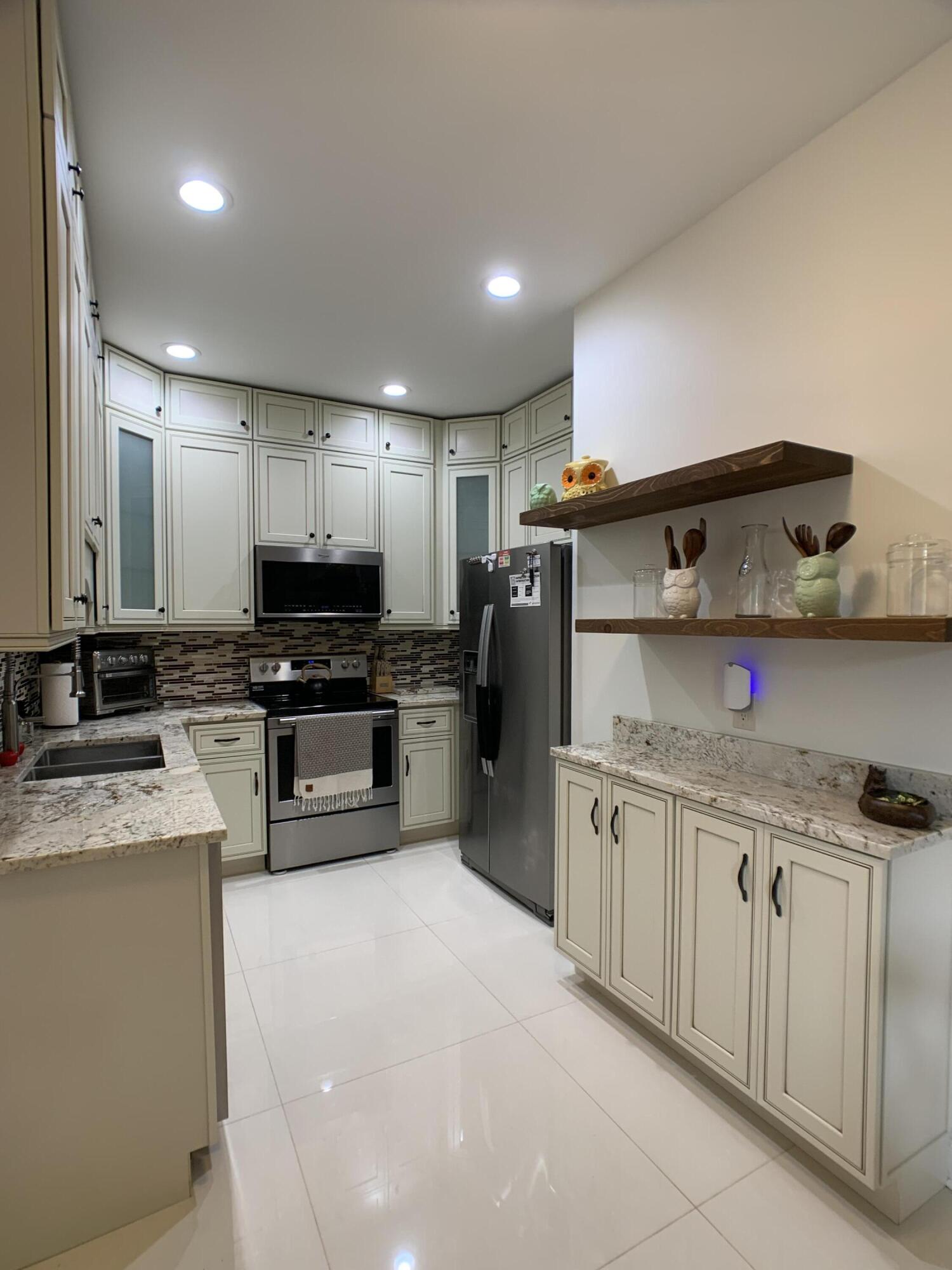 10465 Mateo Court Boca Raton, FL 33498 - Photo 4 of 36 a kitchen with granite countertop cabinets stainless steel appliances and a counter space