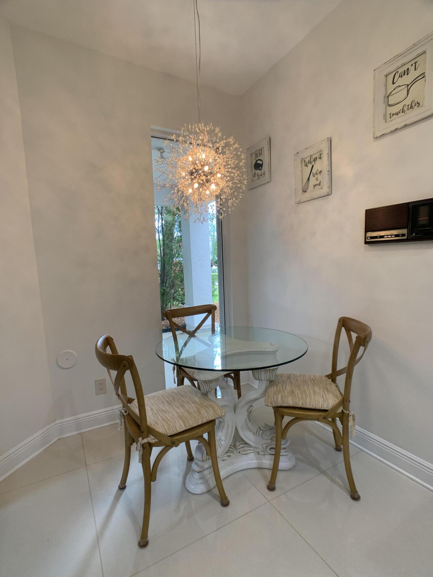 10465 Mateo Court Boca Raton, FL 33498 - Photo 6 of 36 a view of a dining room with furniture and chandelier