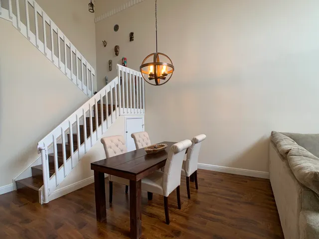 a view of a dining room with furniture wooden floor and a chandelier