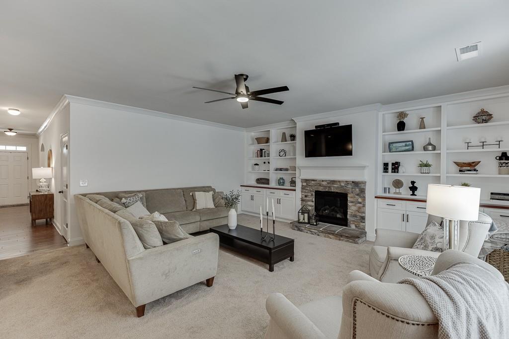 2906 Jones Phillips Road Dacula, GA 30019 - Photo 11 of 53 a living room with furniture a fireplace and a flat screen tv
