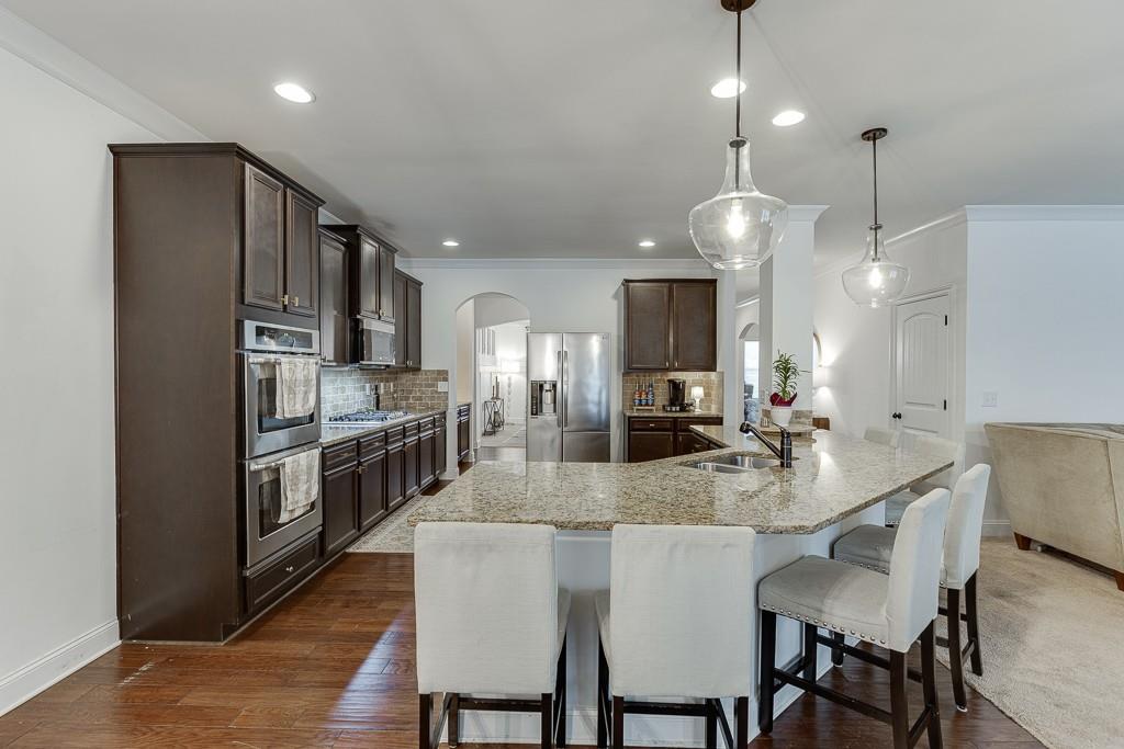 2906 Jones Phillips Road Dacula, GA 30019 - Photo 16 of 53 a kitchen with refrigerator cabinets dining table and chairs