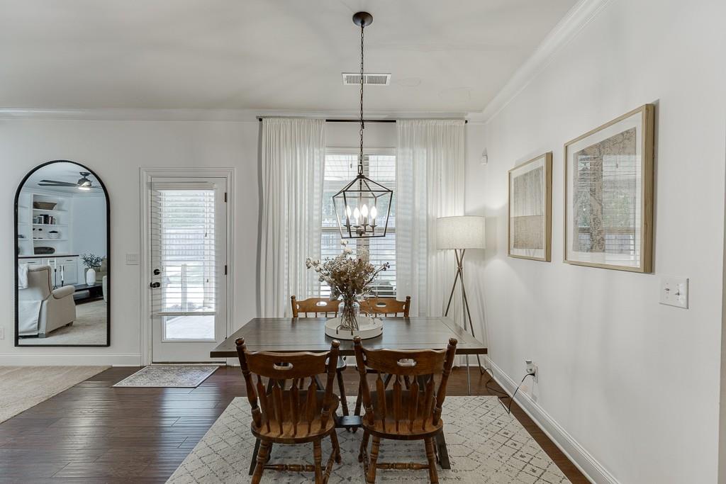 2906 Jones Phillips Road Dacula, GA 30019 - Photo 18 of 53 a dining room with wooden floor a chandelier a wooden table and chairs