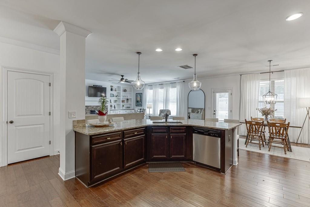 2906 Jones Phillips Road Dacula, GA 30019 - Photo 19 of 53 a large kitchen with stainless steel appliances granite countertop a sink and dishwasher with wooden floor