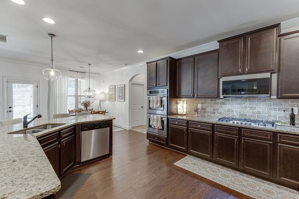 2906 Jones Phillips Road Dacula, GA 30019 - Photo 20 of 53 a kitchen with stainless steel appliances granite countertop a sink stove and refrigerator