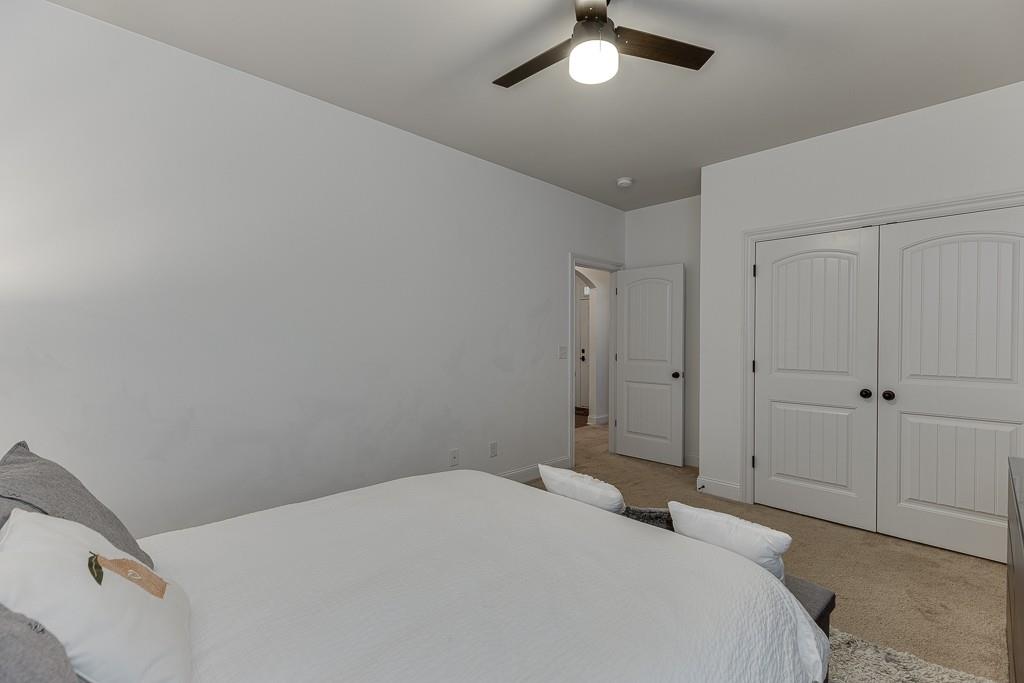 2906 Jones Phillips Road Dacula, GA 30019 - Photo 36 of 53 a bedroom with a bed and a chandelier fan