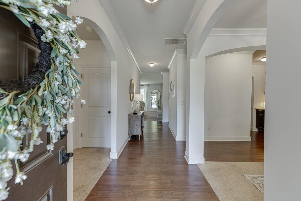 2906 Jones Phillips Road Dacula, GA 30019 - Photo 4 of 53 a view of a hallway with wooden floor and a potted plant