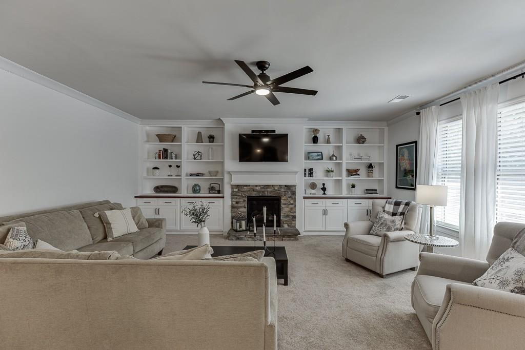 2906 Jones Phillips Road Dacula, GA 30019 - Photo 10 of 53 a living room with furniture a fireplace and a flat screen tv