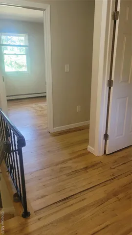 a view of a hallway with wooden floor and stairs