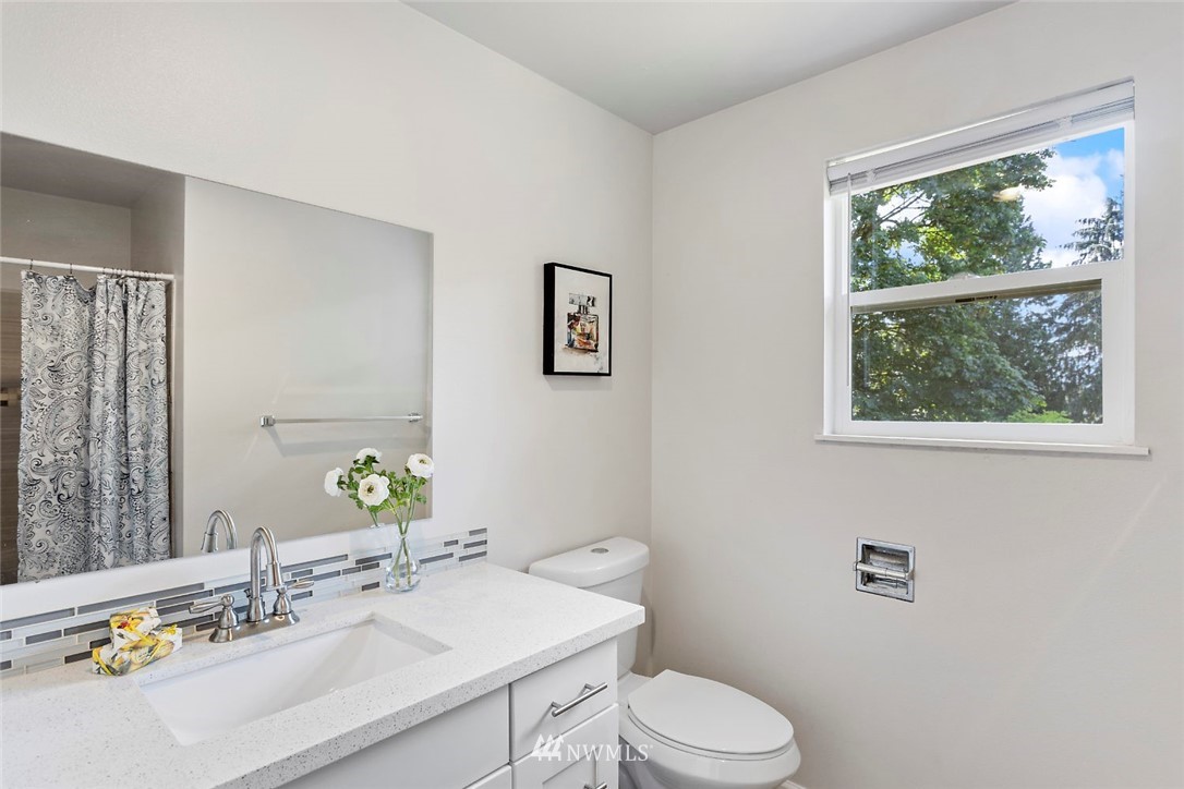6609 Southeast 4th Place Renton, WA 98059 - Photo 19 of 26 a bathroom with a sink vanity mirror and toilet