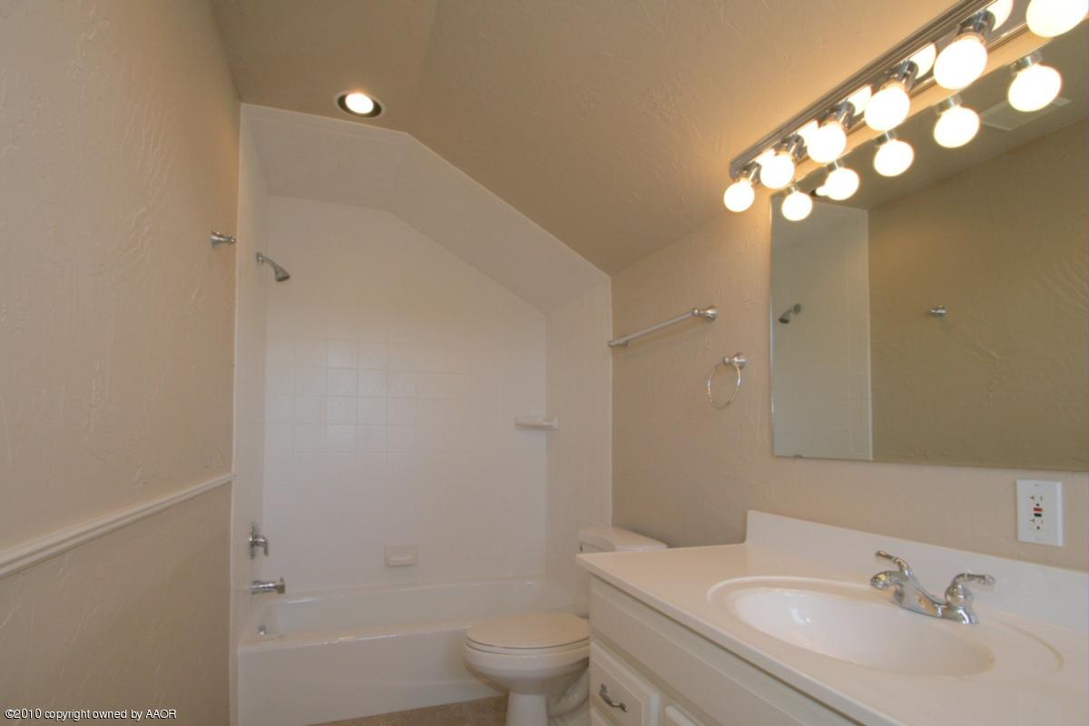 8950 Red Wing Road Amarillo, TX 79119 - Photo 16 of 29 a bathroom with a toilet a sink a tub and mirror