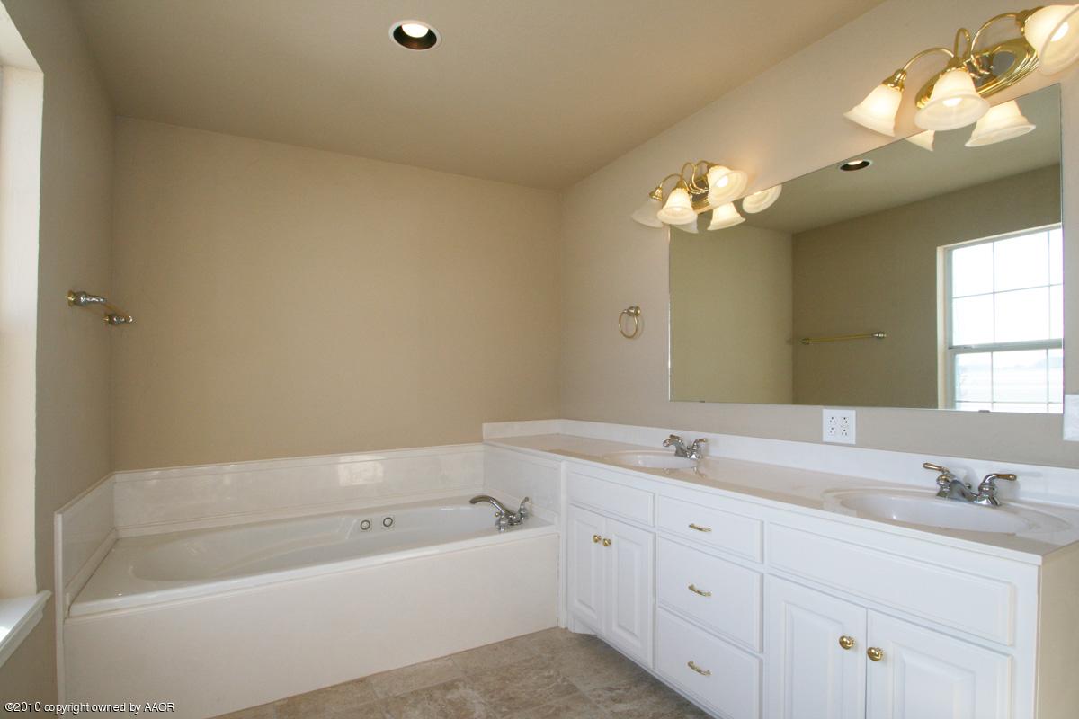 8950 Red Wing Road Amarillo, TX 79119 - Photo 19 of 29 a bathroom with a tub a sink and mirror