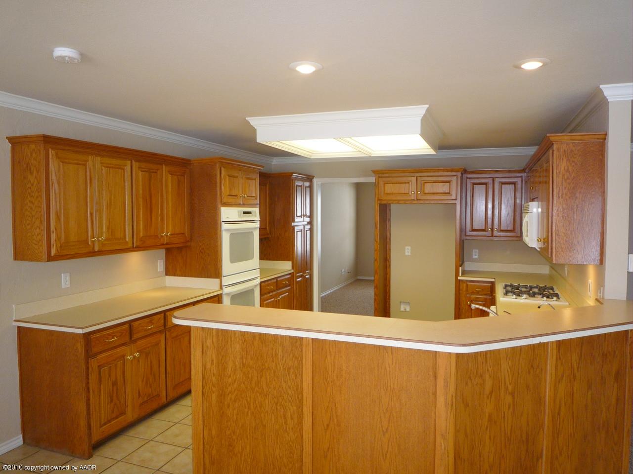 8950 Red Wing Road Amarillo, TX 79119 - Photo 8 of 29 a kitchen with stainless steel appliances a sink cabinets and wooden floor