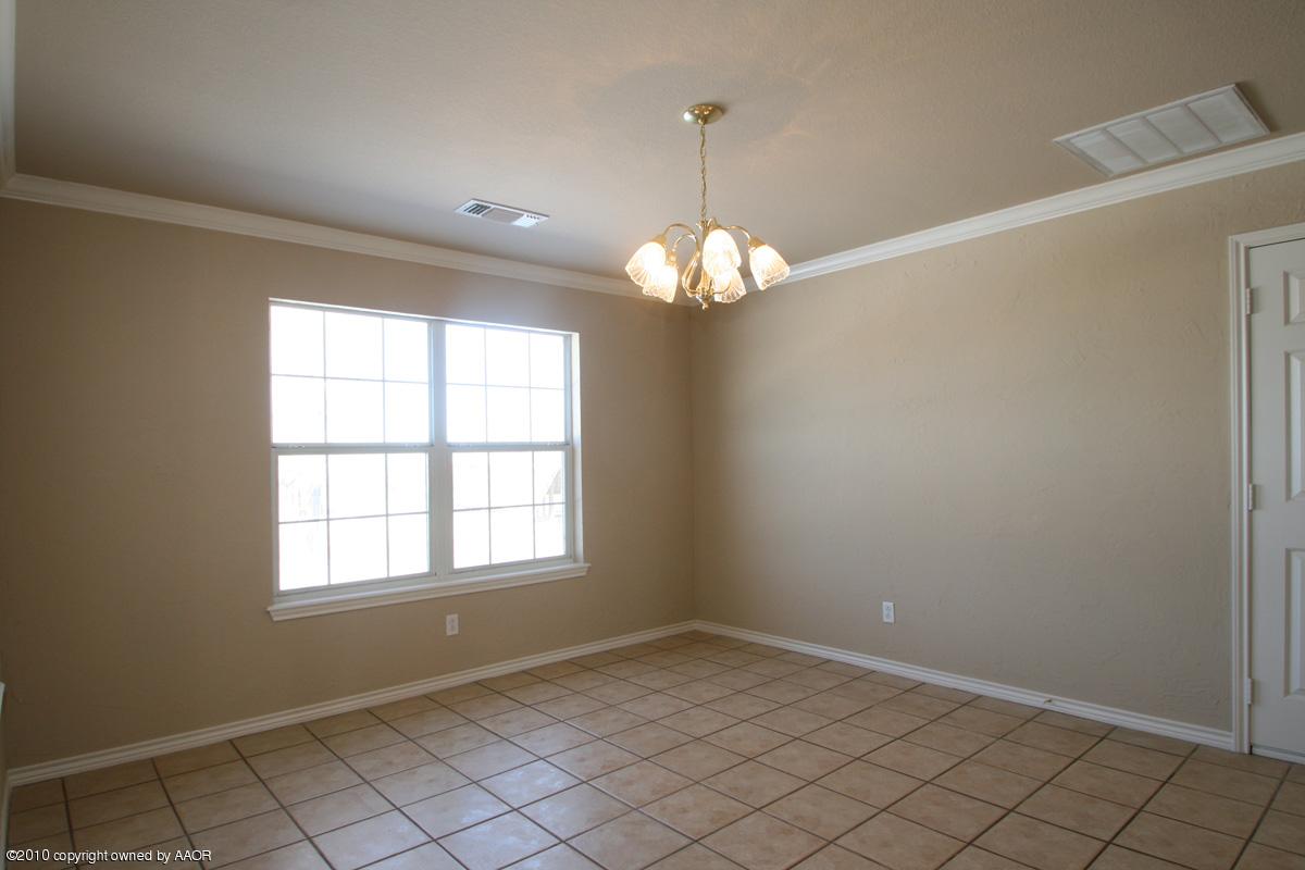 8950 Red Wing Road Amarillo, TX 79119 - Photo 10 of 29 en empty room with windows and chandelier
