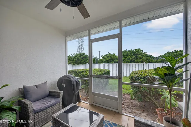 a living room with a floor to ceiling window and wooden floor