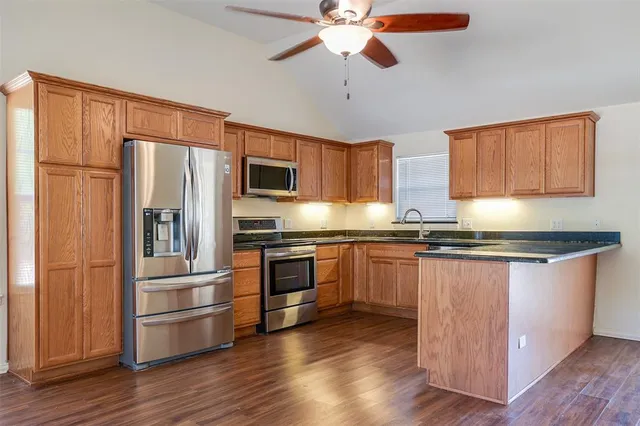 a kitchen with stainless steel appliances granite countertop a refrigerator stove top oven and sink