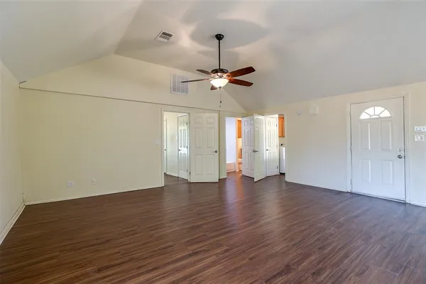 a view of an empty room with window and wooden floor