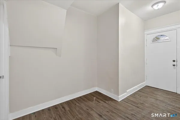 a view of a small space with wooden floor and a window