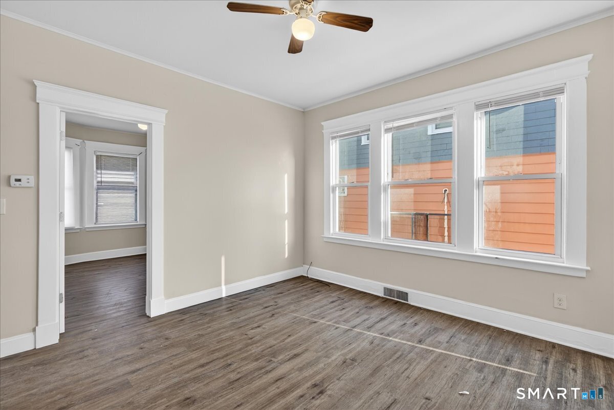 82 Gilbert Street West Haven, CT 06516 - Photo 5 of 12 a view of an empty room with wooden floor and a window