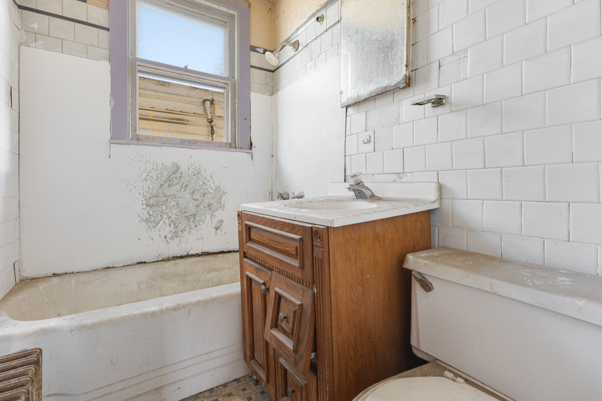 118 East 105th Street Chicago, IL 60628 - Photo 18 of 26 a bathroom with a sink toilet vanity and bathtub