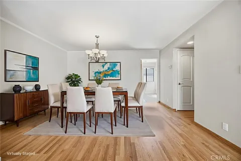 a dining room with furniture a chandelier and wooden floor