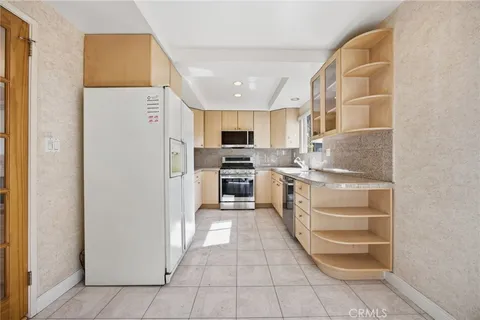 a kitchen with stainless steel appliances a refrigerator and a stove top oven