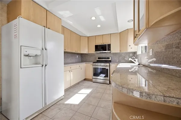 a kitchen with stainless steel appliances a refrigerator sink and cabinets