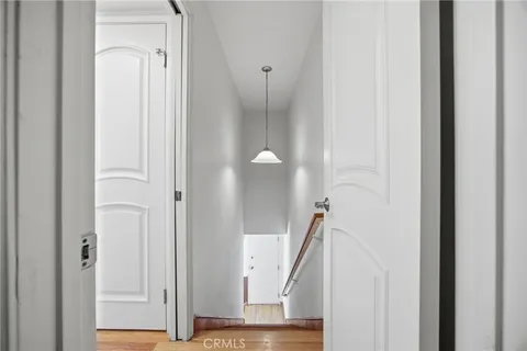 a view of a hallway with white walls and stairs